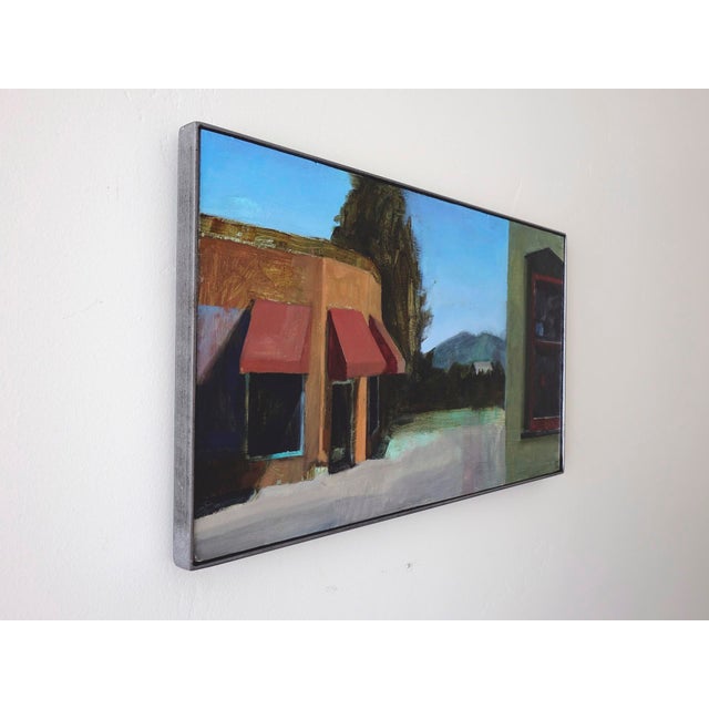 Contemporary Daytime Secret by Emma Kalff | Oil on panel Painting of a street scene with buildings and mountains. For Sale - Image 3 of 5