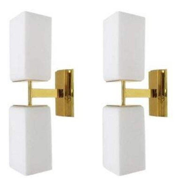 A striking set of eight Italian Modern wall sconces, circa 1990's, featuring clean architectural forms in frosted white...