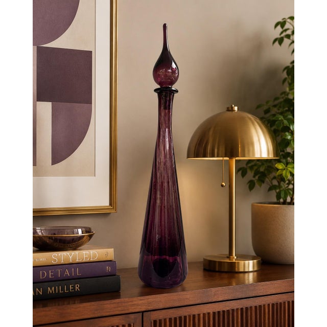 A stunning vintage Italian Empoli genie bottle crafted in rich amethyst art glass during the Mid-Century Modern era. This...