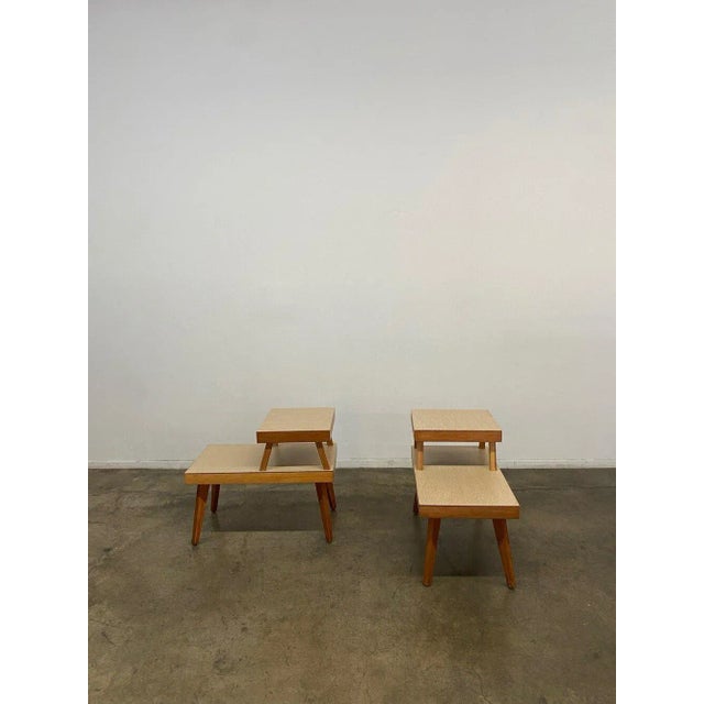 Vintage 1950s Side tables with a two tier design with laminate on the surface and mahogany wood build. The tables are...