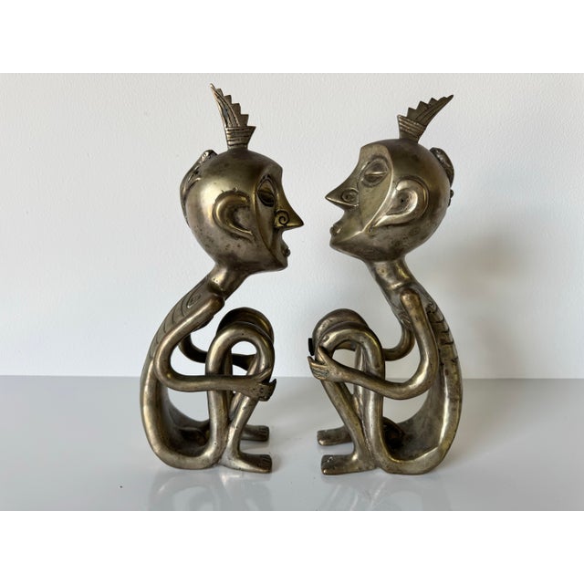 Striking pair of vintage African tribal bronze sculptures, each depicting a stylized nude figure in a seated,...