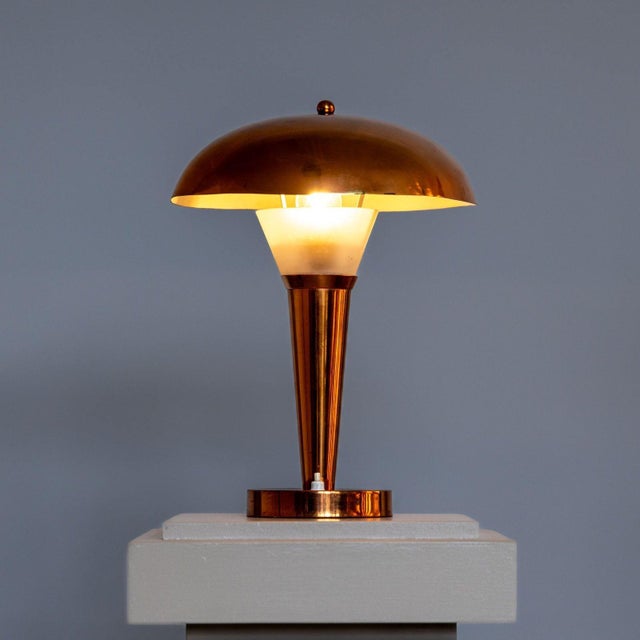 Art Deco copper table lamp with mushroom-shaped lampshade and funnel-shaped base. The upper end of the base is made of...