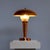 Art Deco copper table lamp with mushroom-shaped lampshade and funnel-shaped base. The upper end of the base is made of...