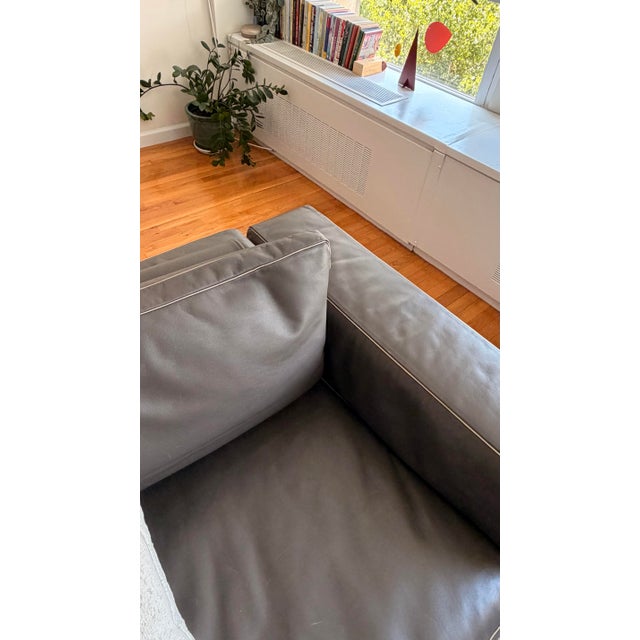 Beautiful Flexform Italian leather sofa in dark grey, featuring a clean, modern silhouette, slim metal legs, and...