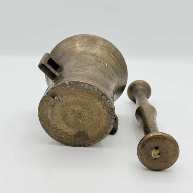 A handsome antique brass mortar and pestle with beautifully aged surfaces and the unmistakable character of a working...