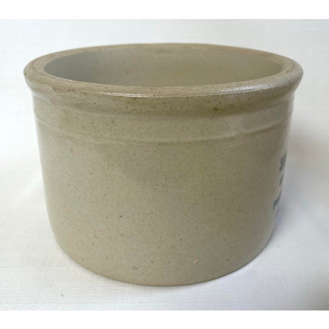 A turn of the century stoneware advertising crock from Red Wing Pottery. It is adorned with an underglaze label from Sam...