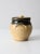 This vintage studio pottery jar brings a warm, organic presence with its speckled tan body and deep olive-brown glazed...