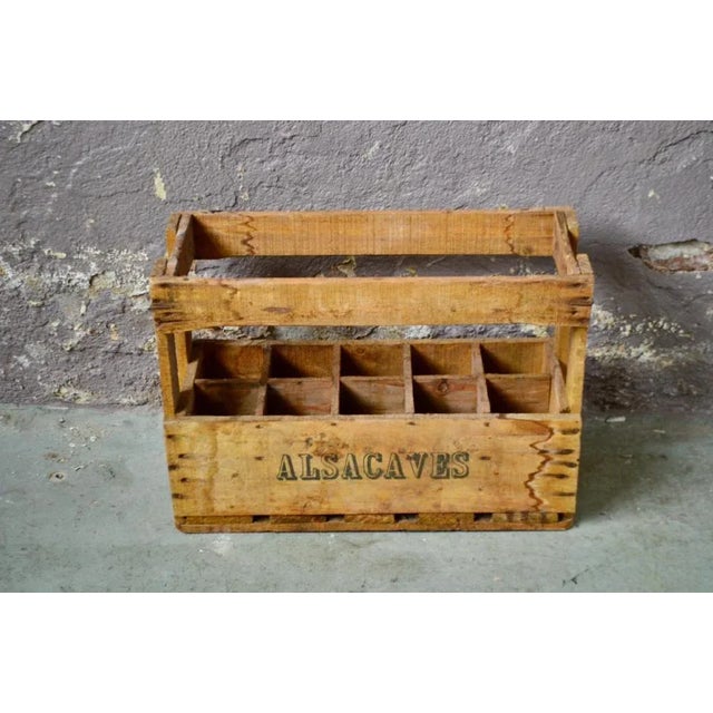 Here is a beautiful vintage bottle case stamped Alsacave. Made of solid wood with a patina finish, the case displays a...
