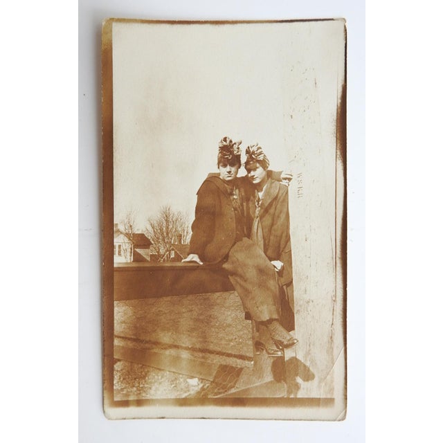 Early 20th century sepai tone snapshot photograph of two young women with arms around each other. Unframed, age toning.
