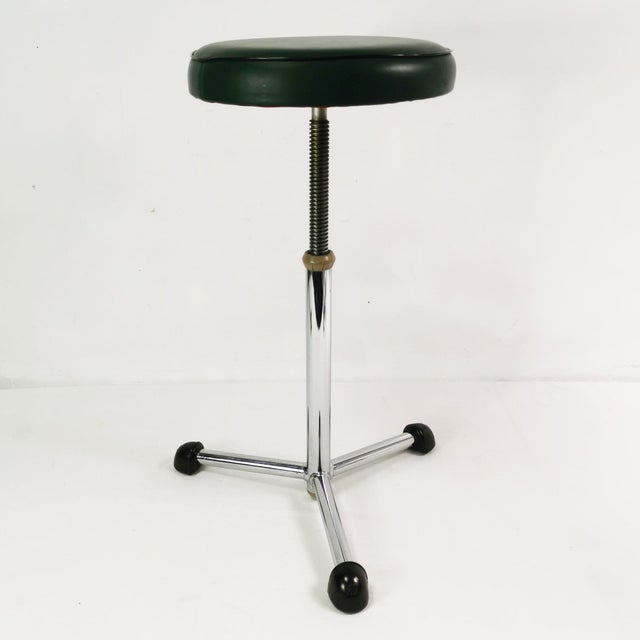 Stool manufactured by Maquet in Germany, 1950s. The piece features a three-legged chrome base ending in distinctive black...