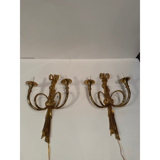 Pair of Italian horn motif brass sconces with tassels and bows.