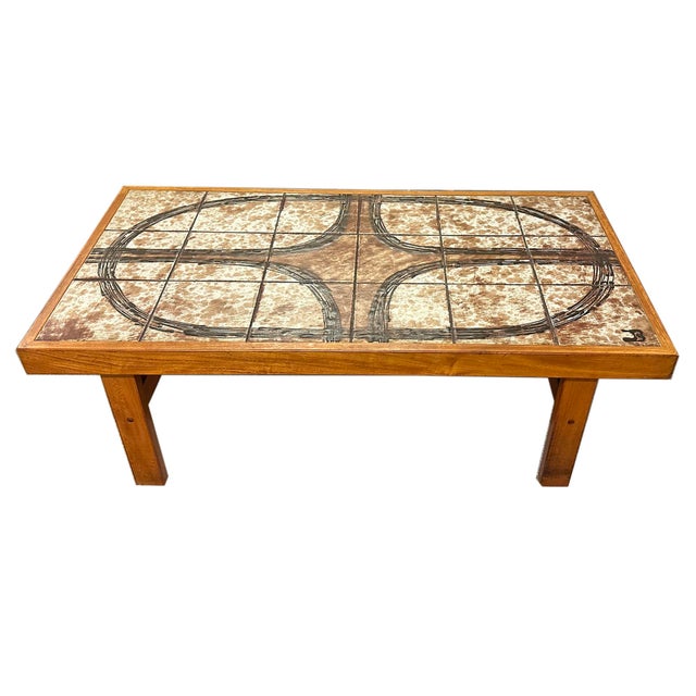 A tile top coffee table by Trioh. Made in Denmark, this table features tiles with a design that form a large oval...