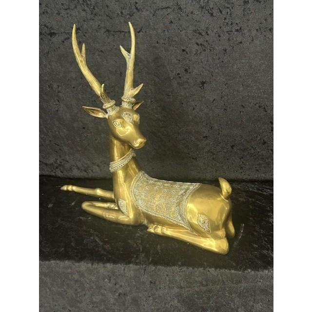 This is a vintage brass sculpture depicting a reclining deer associated with the Hollywood Regency style. Solid brass with...