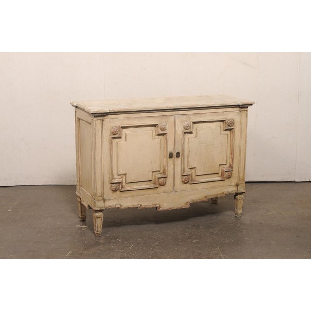 A French painted wood two-door buffet console from the early 20th century. This antique cabinet from France has a...