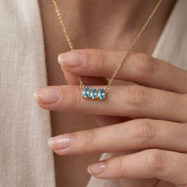 Embrace cool, brilliant sophistication with this stunning two-stone pendant necklace, featuring two clear, sky-blue oval...