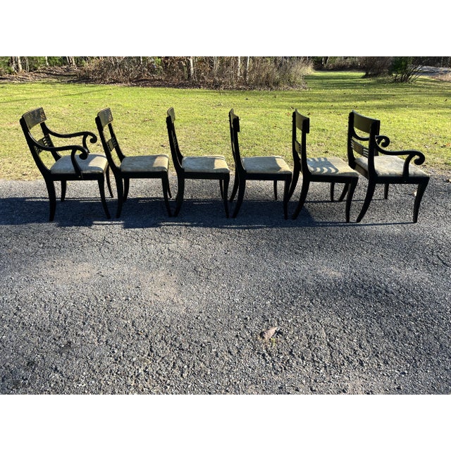 A set of six matching Hollywood regency style wood ding chairs including four side chairs and two arm chairs. Each chair...