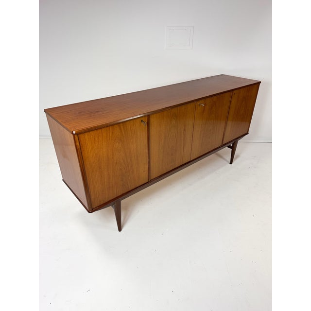 1960's Mid Century Scandinavian Teak Credenza. 4 doors conceal adjustable shelves and drawers. Key included.