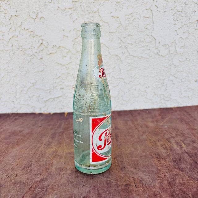 This is a wonderfully distressed 1940s French Pepsi Cola Bottle. It will look great on your shelf or in your man cave and...