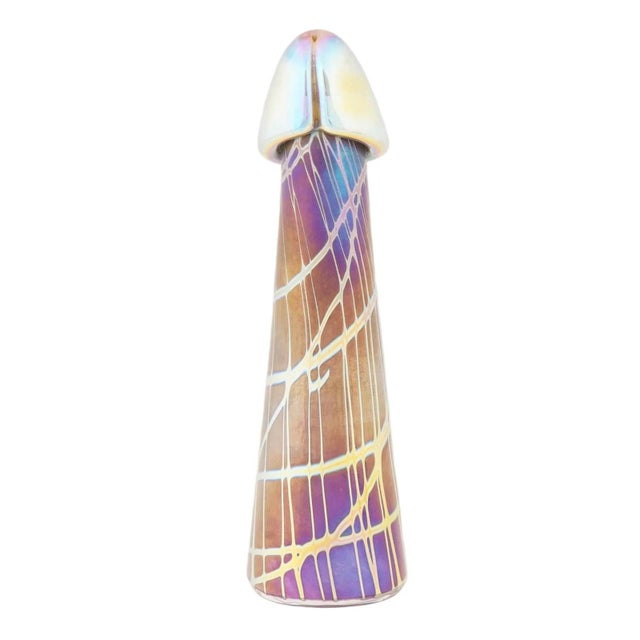 An art glass sculpture representing a phallus. The ware is made in an iridescent design in purple, yellow, blue and orange...