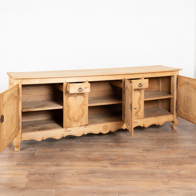 20th century long sideboard from Belgium, crafted in bleached oak. The case features three drawers over four cabinet...