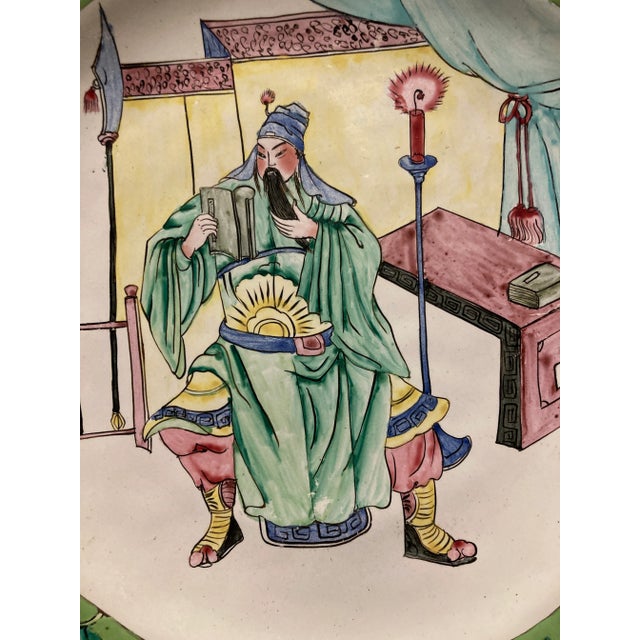 This eye-catching decorative enamel plate features a traditional Chinese figural scene surrounded by floral borders in...