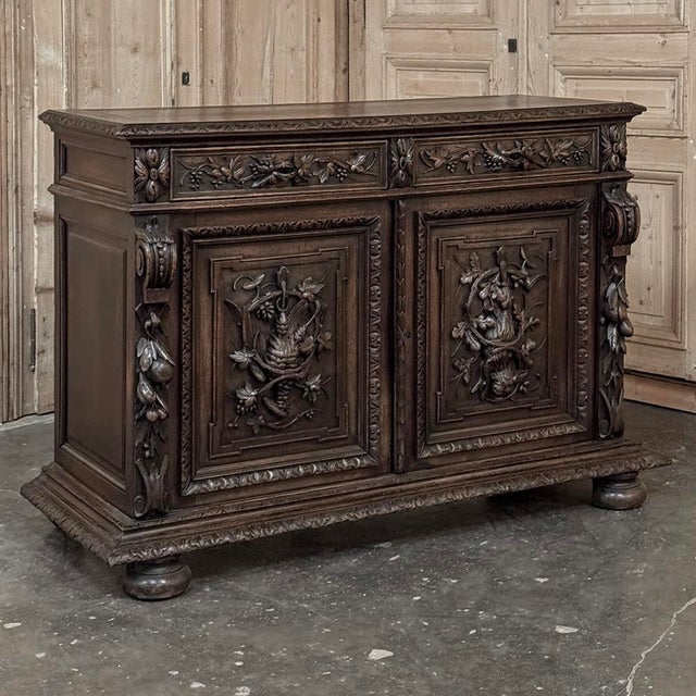 A richly carved 19th century oak hunt buffet executed in the Renaissance Revival style, celebrating the romanticized love...