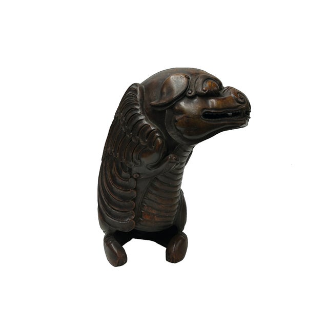 This hand-carved bamboo element depicts a mythical creature, likely a Bixie or a winged lion, characterized by a powerful,...
