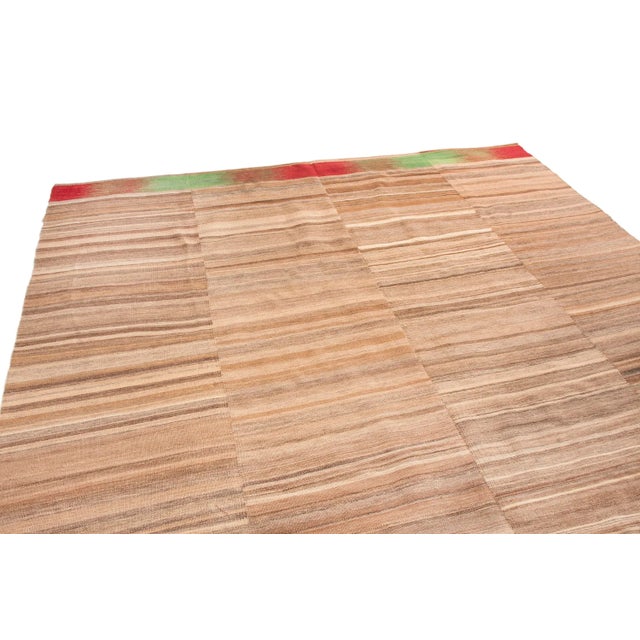 Originating from Pakistan, this modern transitional wool kilim is of a unique family woven in vertical panels, each of the...