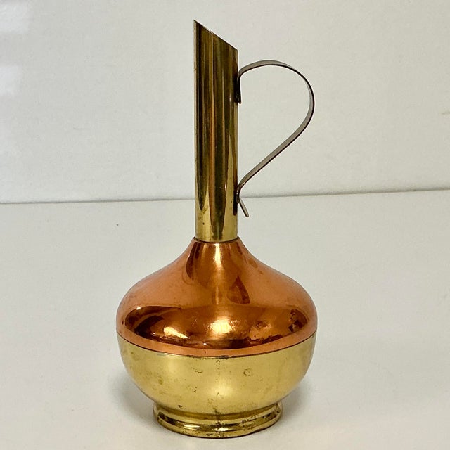 This is a delightful copper and brass Bud Vase from the Mid-Century. It features a globe-like base with a thin cylinder...