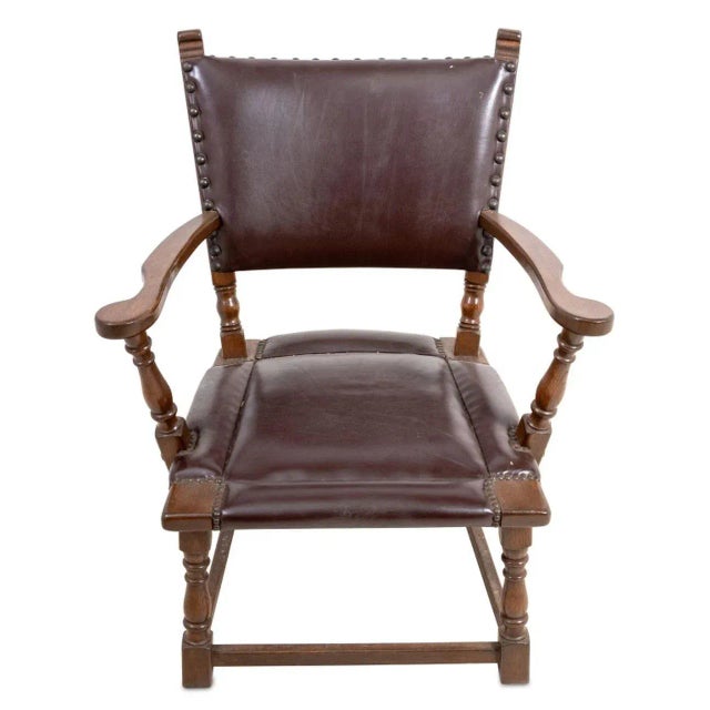 Charles II Style Oak Arm Chair, 20th century, upholstered in brown studded vinyl. 33" H x 28" W x 21" D; seat: 15" H.
