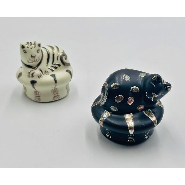 A whimsical and beautifully crafted pair of porcelain and pure silver salt and pepper shakers designed and handmade in...