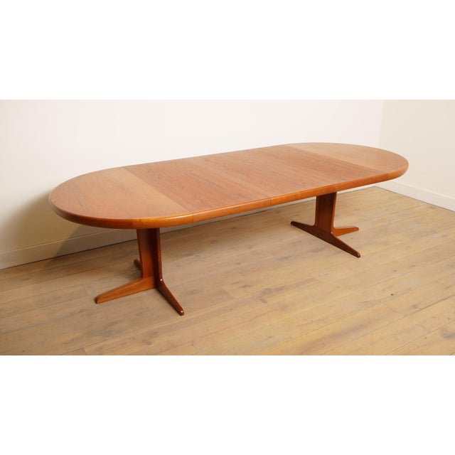 This vintage round Danish dining table is made of teak. The round wooden dining table can be extended with as many as 3...