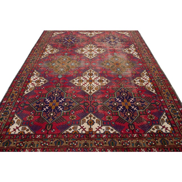 Beautiful antique Tabriz hand-knotted wool rug with a red field. This Persian piece has blue, goldenrod, and beige accents...