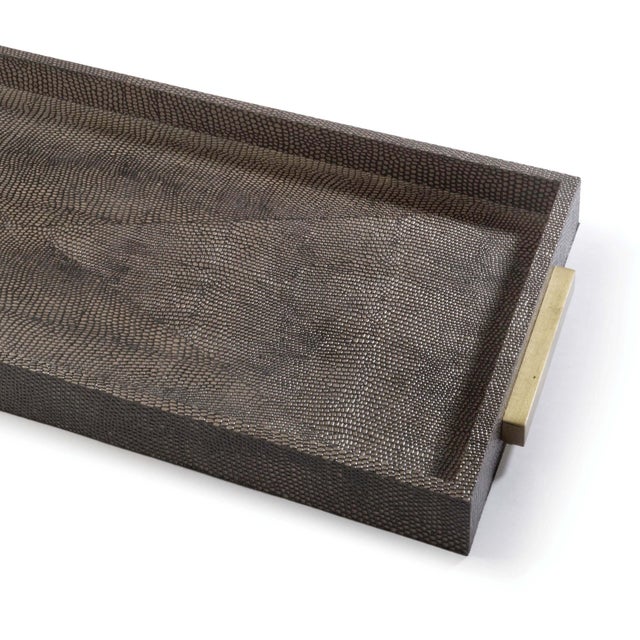 Wrapped in brown faux shagreen, this rectangular tray sports complementary natural brass handles. Perfect to display...