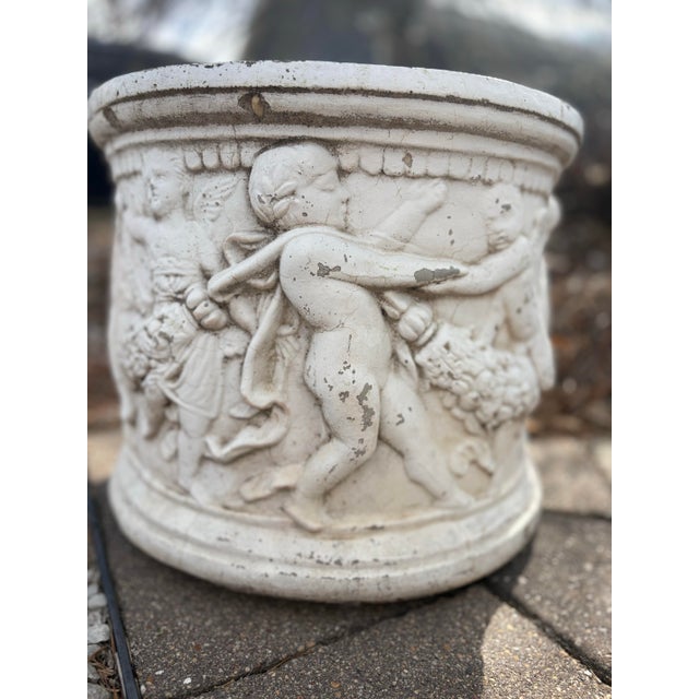 A set of 2 beautifully aged vintage cast stone planter featuring a continuous frieze of classical cherubs (putti) in high...