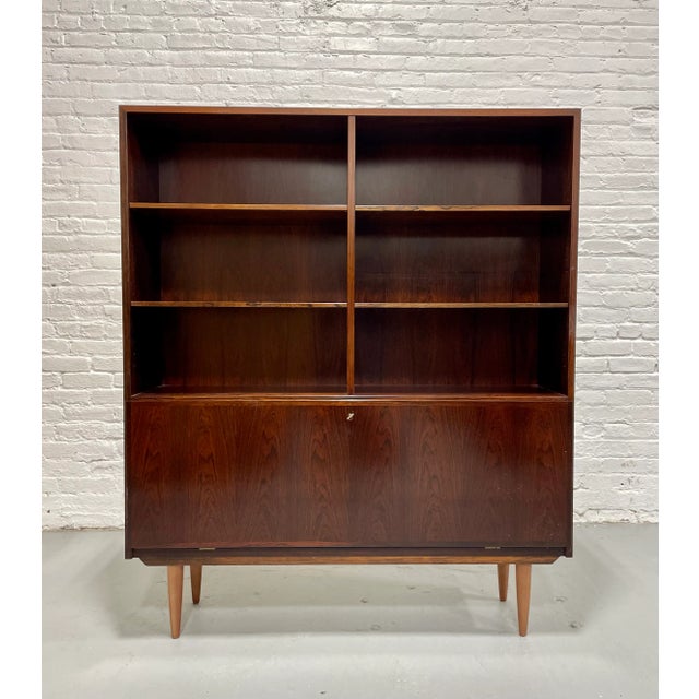 Exquisite Mid Century Modern ROSEWOOD bookcase / China Cabinet, c. 1960's. This stunning piece features 6 shelving areas...