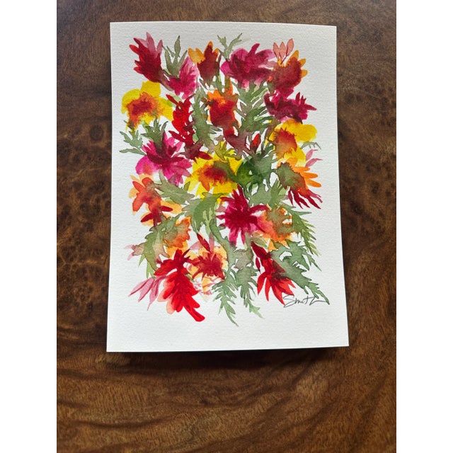 A lively and expressive bouquet bursts to life in this vibrant watercolor, featuring rich shades of crimson, orange, and...