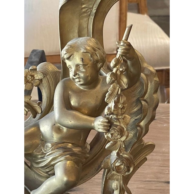 The product is a pair of 19th century French gilt bronze chenets, which are ornate fireplace accessories that add a touch...