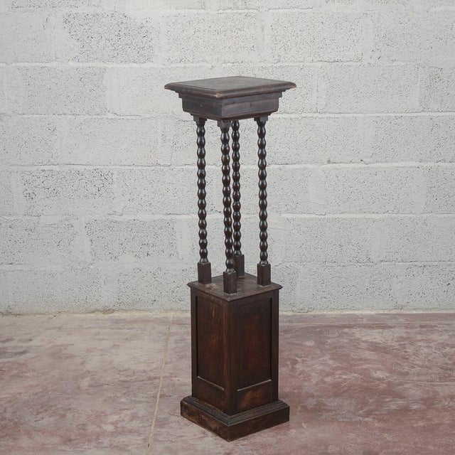 This entryway plant stand, dating back to the early 20th century, reflects the understated taste and solidity typical of...