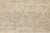 Natural hand-knotted wool rug in warm Cream Beige and light Ancient Grain with subtle geometric triangle patterns. The...