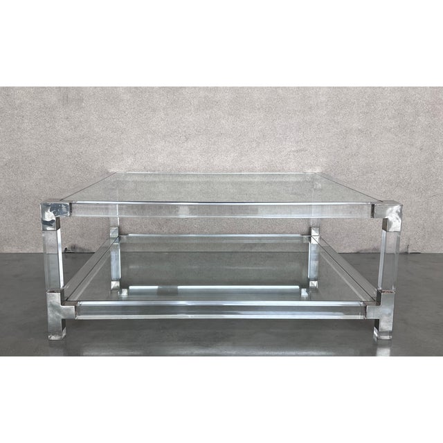 Pair of midcentury square lucite coffee tables with chromed metal details. We have matching pair square coffee table...