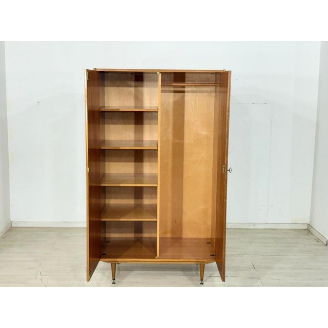 This impressive mid-century wardrobe from the 1960s captivates with its exceptionally vibrant veneer, showcasing a...