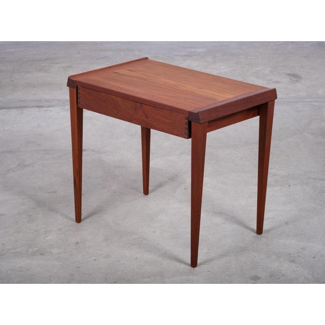 Elegant Danish side table from the 1960s, crafted in teak and featuring a drawer with beautifully executed dovetail...