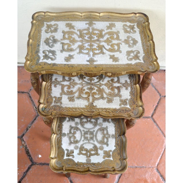 1970s Set of 3 Giltwood Florentine Nesting, Stacking tables featuring cabriole legs with intricate hand painted details on...