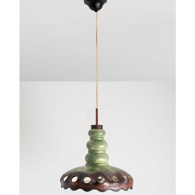 Beautiful round hanging lamp with an unusual shape, made with brown and green ceramic, manufactured in the 1970s in...