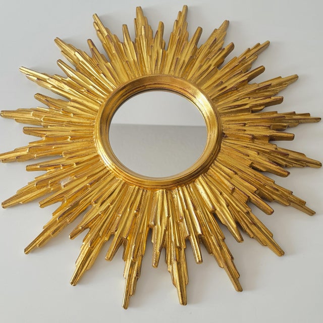 A beautiful, gold-colored sunburst mirror, made in Belgium in the 1970s. This striking mirror is designed in the shape of...