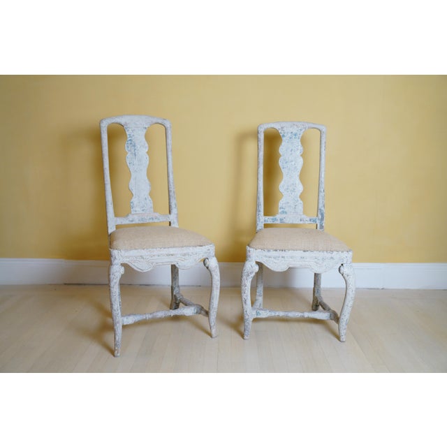 A fine pair of mid-18th-century Swedish Rococo side chairs, each with an elegantly shaped serpentine back splat, scalloped...
