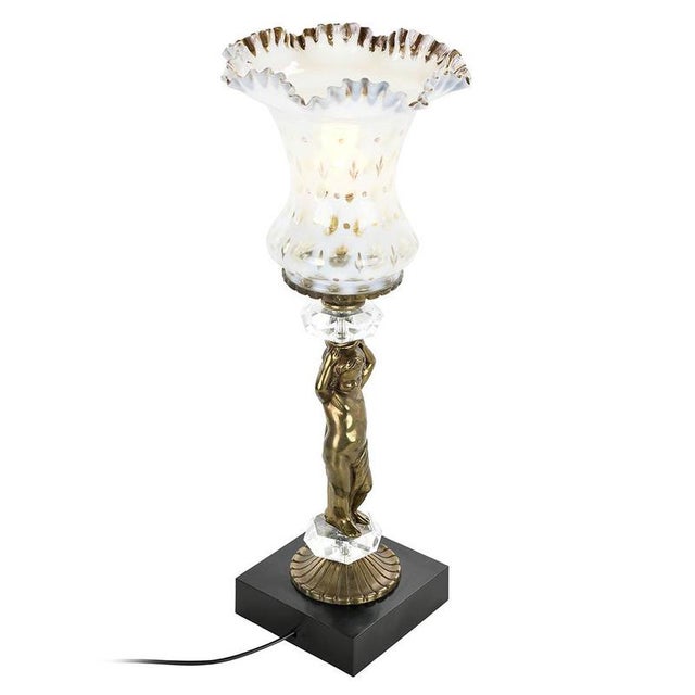 This elegant table lamp is a real decorative gem, combining noble materials such as bronze, crystal and opaline. The body...