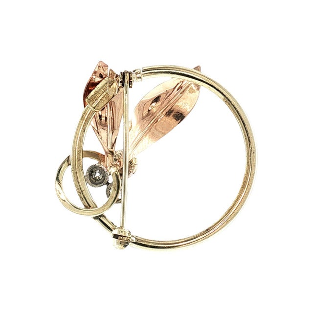 A charming 40s brooch by Forstner Chain Co. Crafted in 10k gold. Features two rose gold leaves. Adorned with three old...