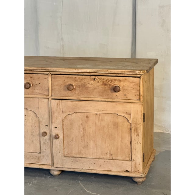 A charming English pine dresser with two drawers over a pair of paneled cupboard doors, finished with simple wooden knobs...